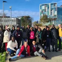 A group of people in front of a building with blue skies