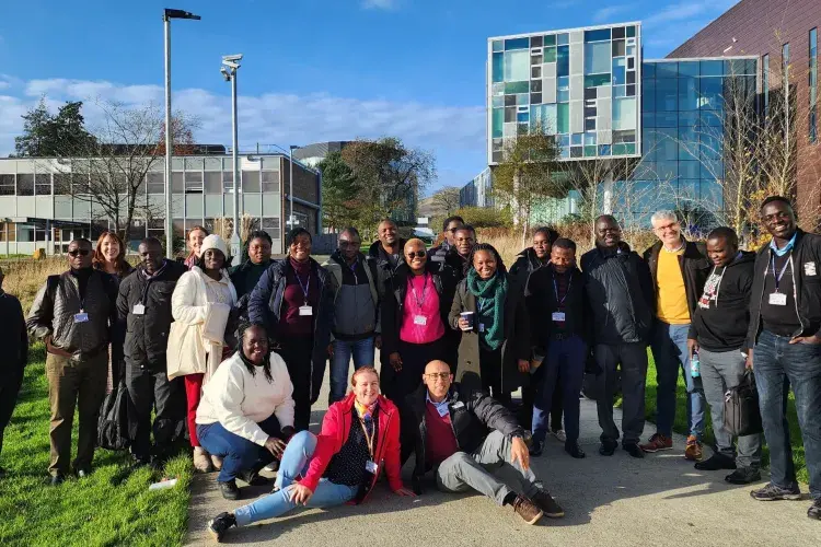 A group of people in front of a building with blue skies