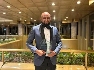 Hussein Mohammed, Managing Partner of Distory Communications, proudly holding the Regional AMR Champion Media Award at the ceremony in Harare, Zimbabwe.